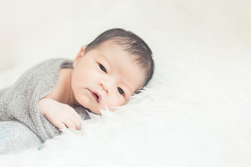 New born baby lying on a soft blanket. Cute  new born baby in natural motion.