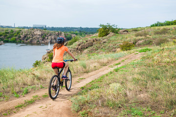 Fototapeta na wymiar Young woman riding a mountain bike, an active lifestyle.