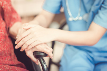 Hand of  eldery  woman with her caregiver at home. Home care or Elderly care concept.