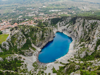 Fototapeta na wymiar Blue Lake (Croatian: Modro jezero or Plavo jezero) is a karst lake located near Imotski in Croatia. It lies in a deep sinkhole possibly formed by the collapse of an enormous cave.