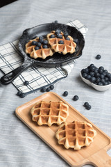 Belgium waffle with blueberry topping in the pan on the tablecloth