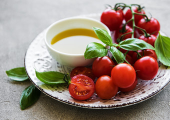 Plate with cherry tomatoes, olive oil and basil