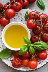 Plate with cherry tomatoes, olive oil and basil