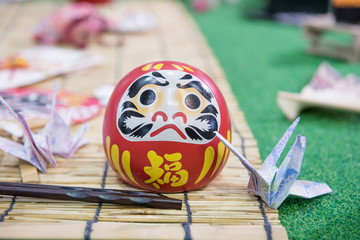 Daruma doll japanese symbolise and paper bird