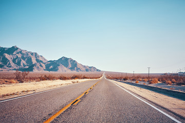 Retro stylized picture of a desert road, color toned picture, USA.