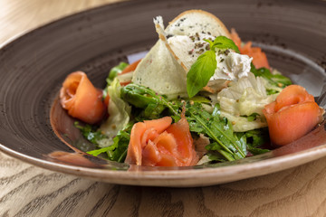 Red fish healthy salad with mixed lettuce leaves