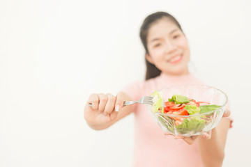 Enjoyed Asian woman eating vegetable salad.