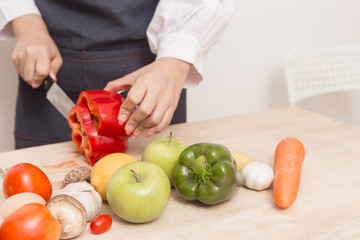 Young Woman Cooking Healthy Food   and Vegetable Salad in the kitchen at home.  Healthy Lifestyle.