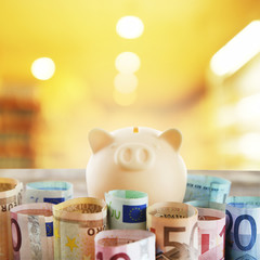Piggy bank with money on blurred background
