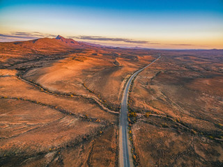 The Outback Highway passing through Flinders Ranges at dusk - aerial view
