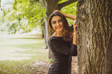 Young fashionable beautiful hispanic woman in  garden, natural look, sensual, little black dress, summer vacation, slim body, sexy, trendy style 