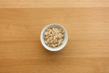 brown rice on the bowl, wood table.