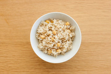 brown rice on the bowl, wood table.
