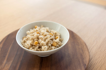 brown rice on the bowl, wood table.