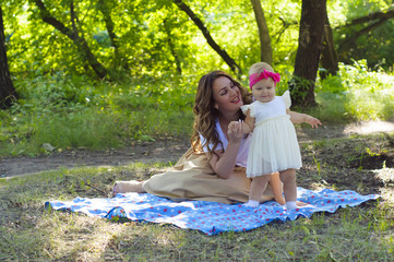  Happy family. Mother with the little daughter play in the park