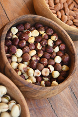 close up of hazelnut and almond with pistachios in wooden bowl 