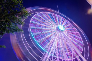 Ferris wheel at amusement park during night time. Long exposure photography
