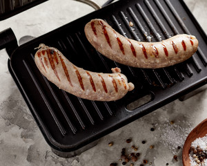 Raw pork sausages on grill pan