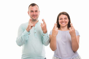 Portrait of young happy couple showing double cross fingers gesture