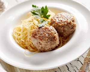 Pasta with two cutlets on rustic white table