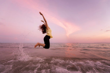 Fototapeta na wymiar Asian pretty woman is jumping and relax on beach. Positive emotions. Summer concept.