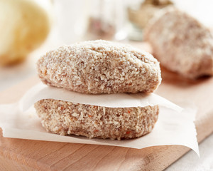 Raw chicken cutlets on wooden cutting board