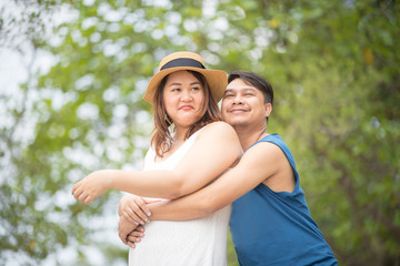 Fototapeta premium Happy chubby lover couple are posting on the rock.