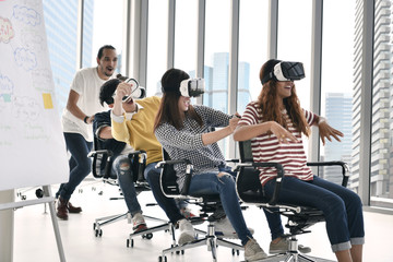Group of young businesspersons having fun with vr virtual reality at office