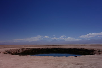 Salzsee in der Wüste vor Vulkan-Kulisse