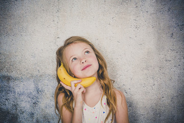 blond, Pretty girl is doing phone call with a banana