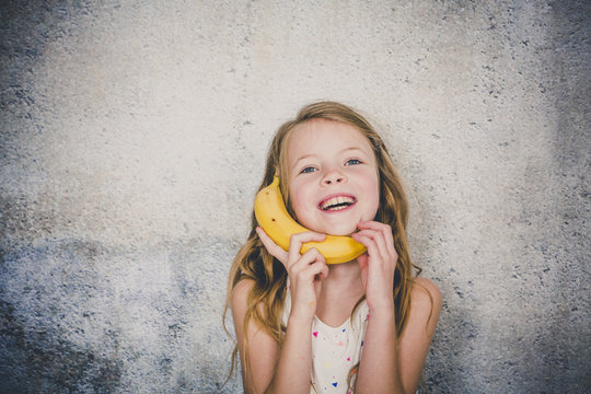 blond, Pretty girl is doing phone call with a banana