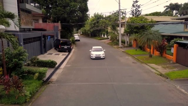 White Car Passing in a Subdivision