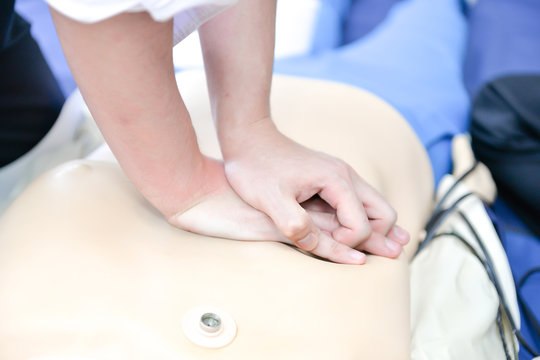 Basic Life Support Of Demonstrating Chest Compressions On CPR Doll