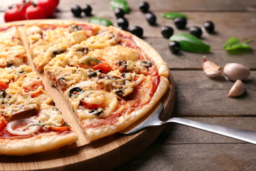 Tasty sliced pizza on wooden table, closeup