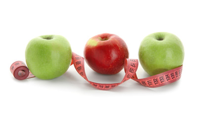 Apples and measuring tape on white background. Diet food