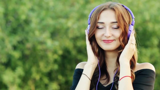 dremy teenager in headphones listening to music on nature