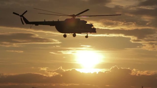 Helicopter takes off with sunset