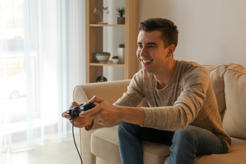 Young man playing video game at home