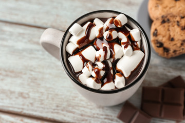 Cup of hot chocolate with marshmallows on wooden table