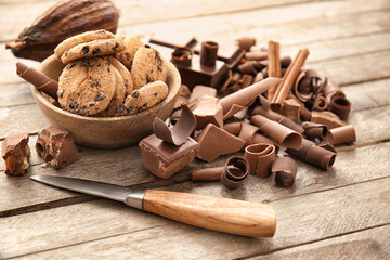 Delicious chocolate curls with cookies on table