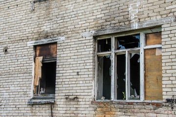 Fototapeta na wymiar Broken Windows and glass in an old, abandoned brick house