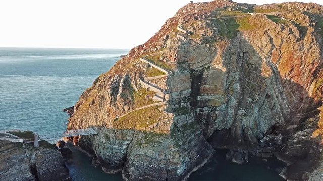 Aerial view of South Stack with lighthouse and cliffs during sunset