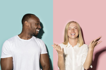 Fototapeta premium happy afro man and woman. Dynamic image of caucasian female and afro male model on pink studio.