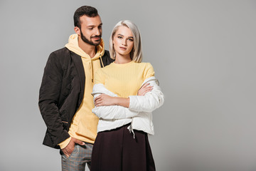 stylish couple of models posing isolated on grey background