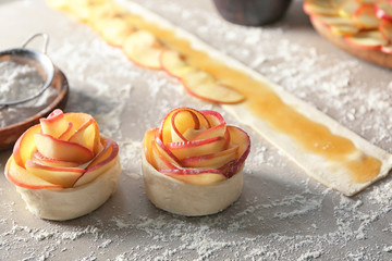 Raw rose shaped apple pastry on table