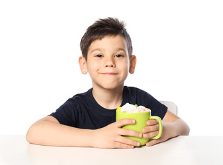 Cute little boy with cup of hot cocoa drink on white background