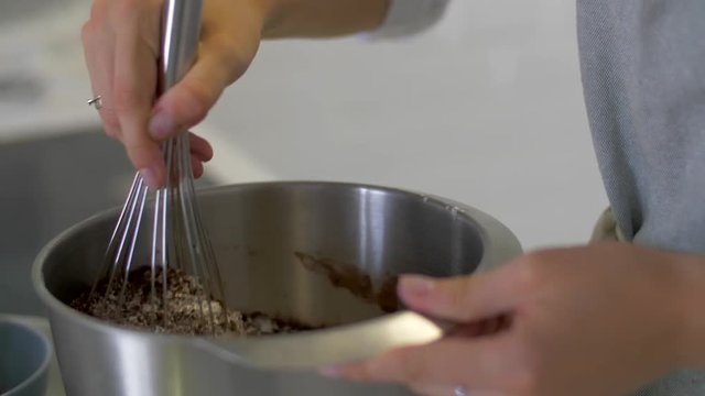 Women's hands mix hot chocolate with a whisk