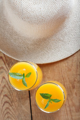 Healthy pumpkin fruit smoothie with straw hat on vintage wood background