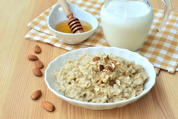 Oatmeal with honey and almond nuts, nutrient rich breakfast. 