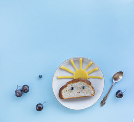 on a blue background breakfast morning sun cloud sky rays rays cute sandwich healthy food berries blueberries plum bread cheese plate spoon serving
